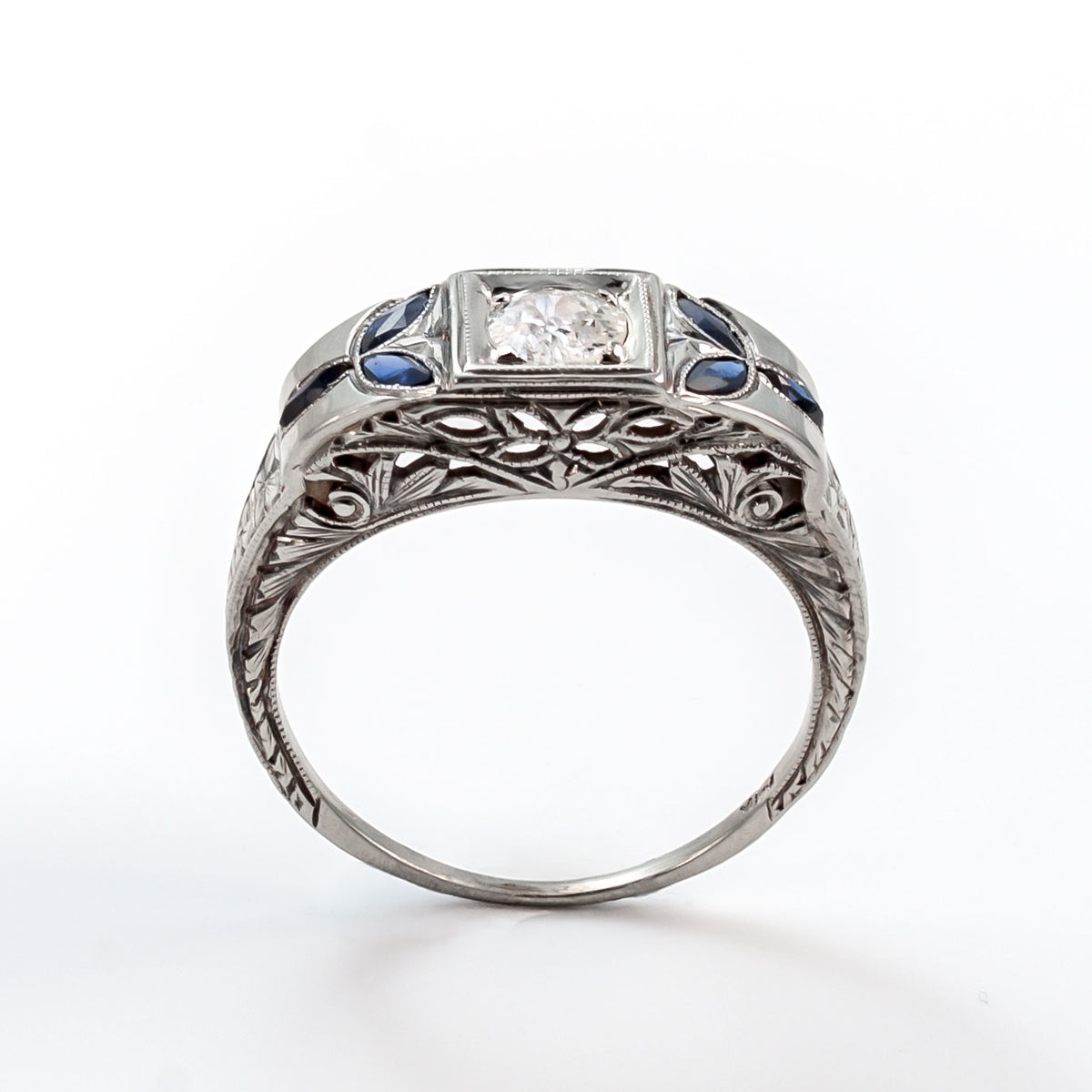 Top view of an 18k white gold Art Deco shield ring with a 5mm central diamond and marquise sapphire accents.