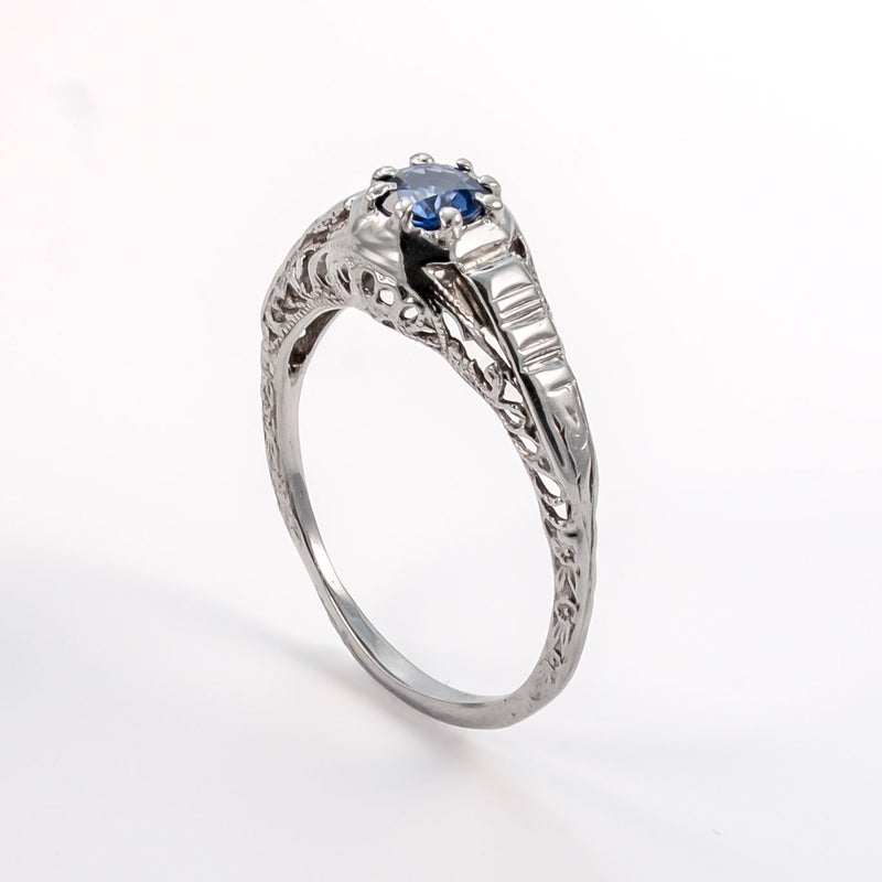 Angled upright image of vintage sapphire ring showing architectural shoulders and white gold craftsmanship
