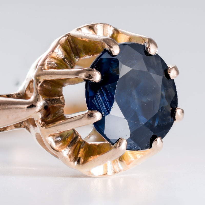 Side view showing the detailed openwork crown and "petal" prongs of a transition-era sapphire solitaire ring.