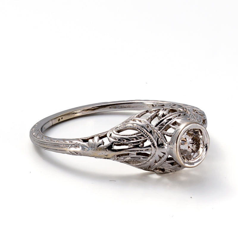 Left profile showing the openwork filigree, engraved shoulders, and elegant gallery of this antique engagement ring.