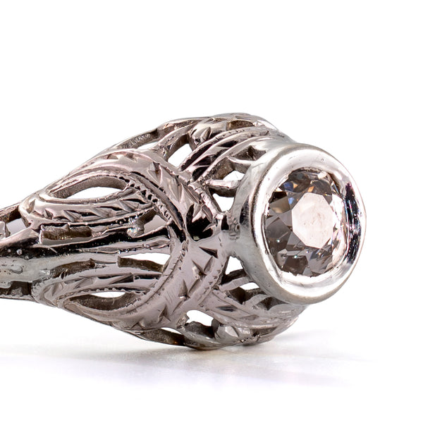 Detailed macro photograph of the bezel-set antique diamond with beautifully engraved shoulders and intricate openwork.