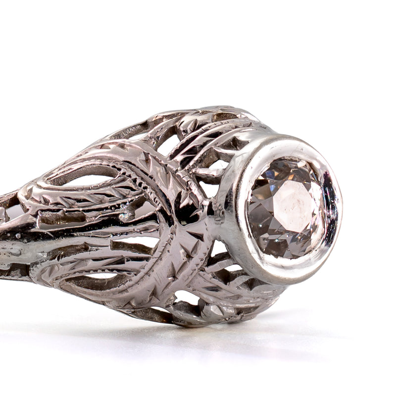 Detailed macro photograph of the bezel-set antique diamond with beautifully engraved shoulders and intricate openwork.