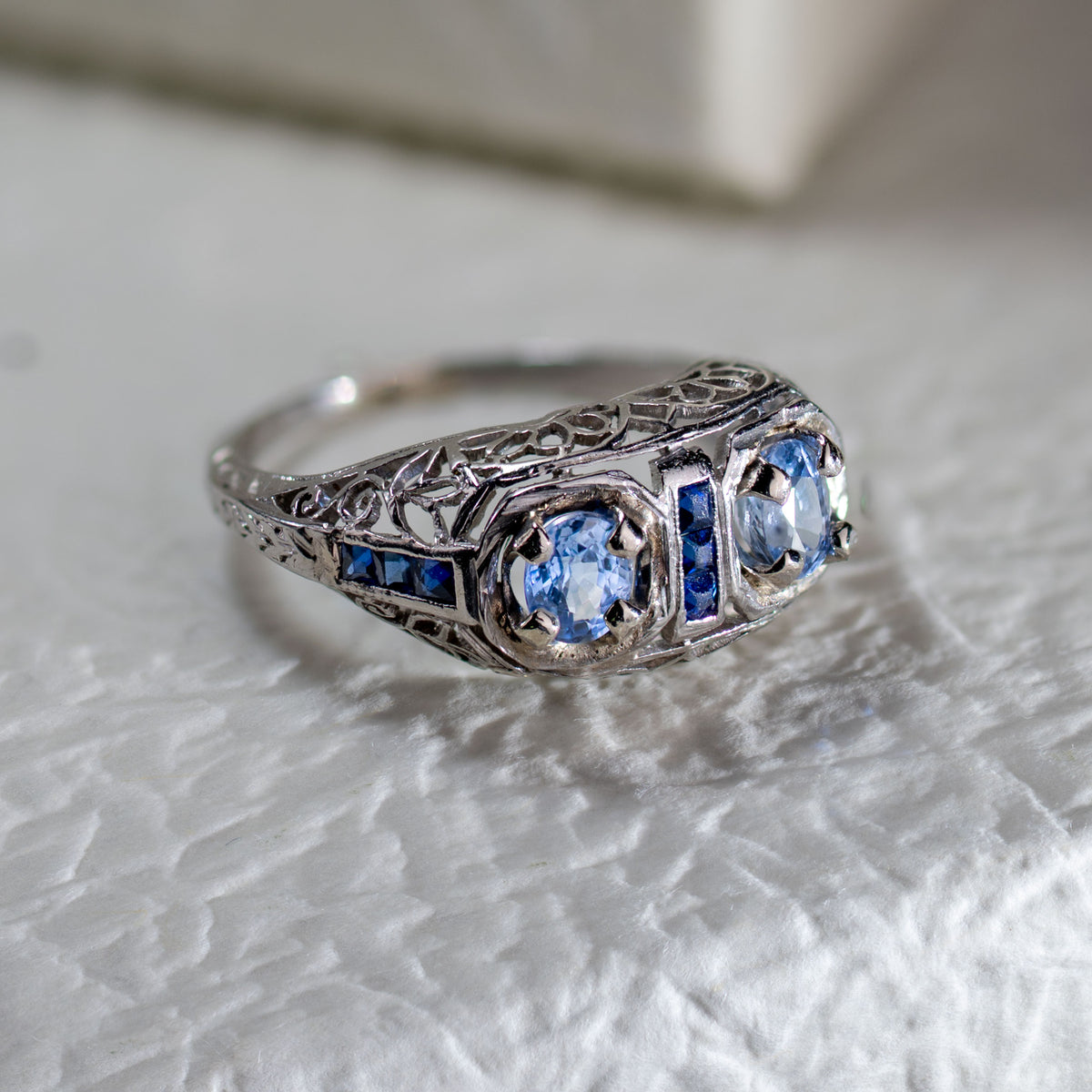 Antique late Edwardian filigree ring with two GIL certified natural no-heat blue sapphires in 18K white gold.