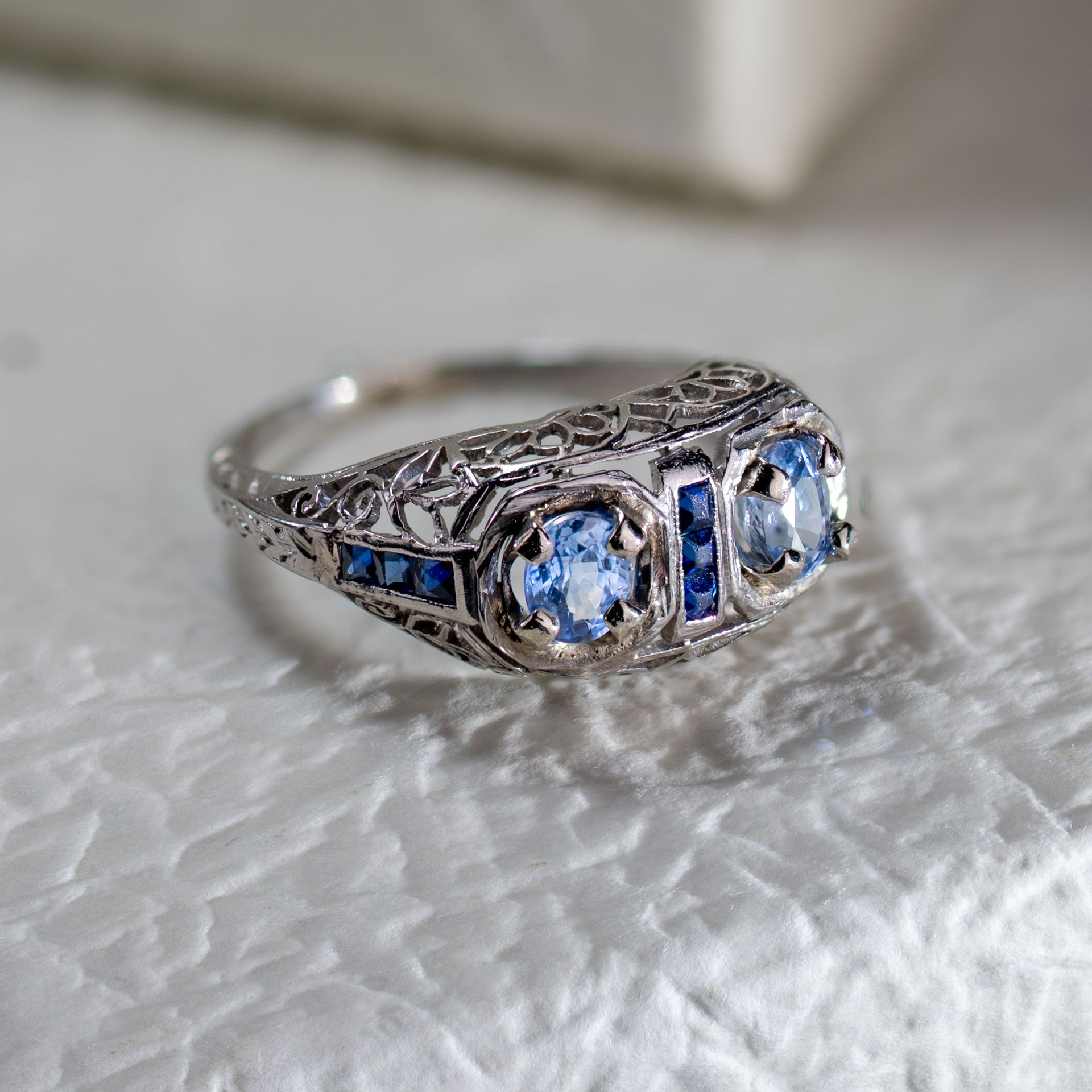 Antique late Edwardian filigree ring with two GIL certified natural no-heat blue sapphires in 18K white gold.