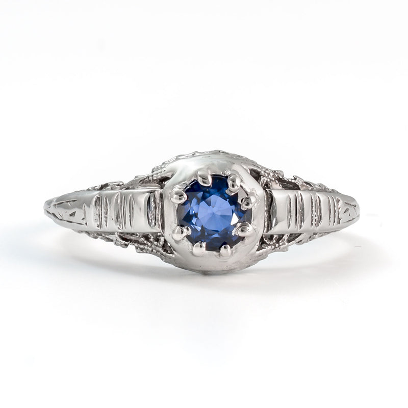 Front view of antique sapphire ring featuring natural blue sapphire and delicate filigree