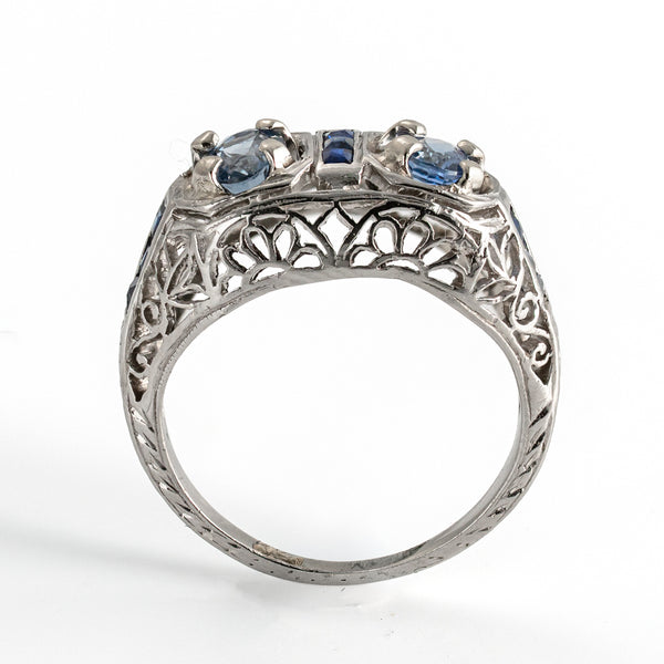 Upright view showcasing the elegant architecture and elevated setting of an antique sapphire ring, highlighting the filigree work.