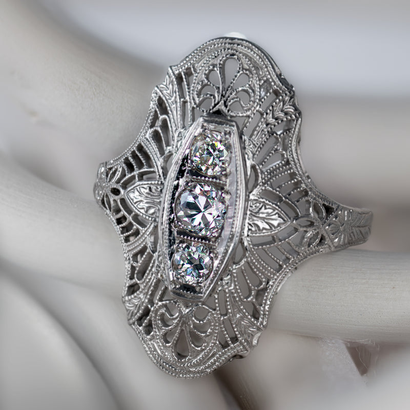 Authentic 1920s Art Deco three-stone diamond filigree navette dinner ring in 18K white gold.