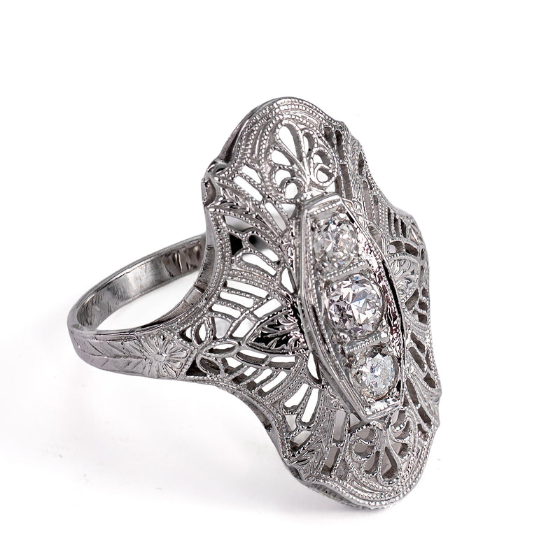 Left profile angle highlighting delicate floral filigree and hand-engraved white gold band.