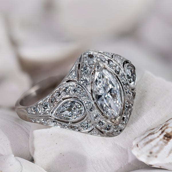 Three-quarter perspective view of antique Art Deco diamond navette ring on coral display