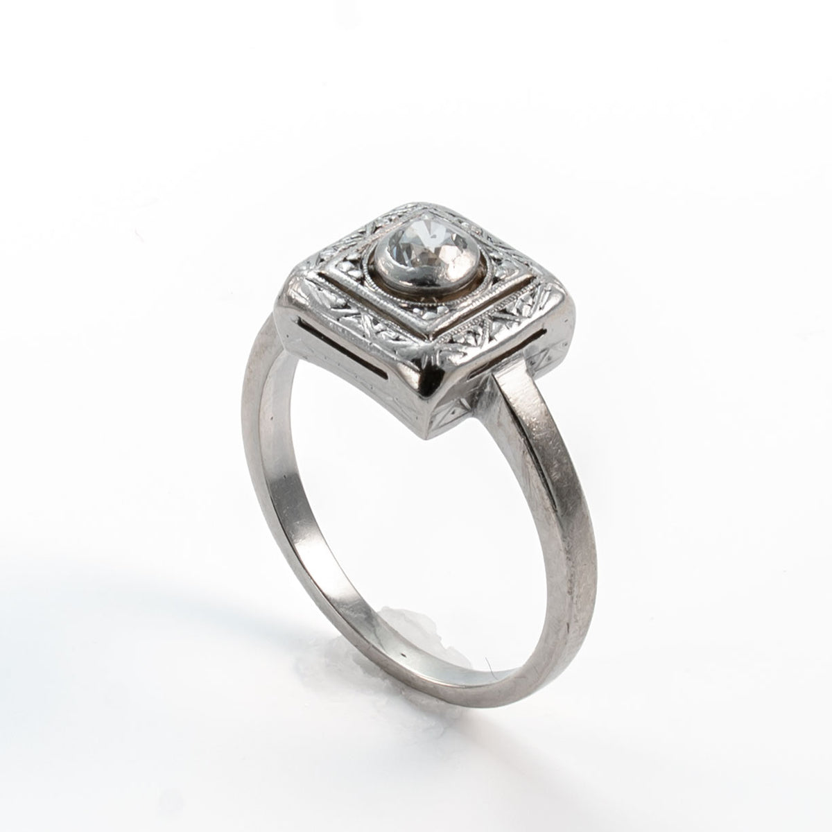 Angled view of a late Art Deco Old European cut diamond ring with recessed bezel setting