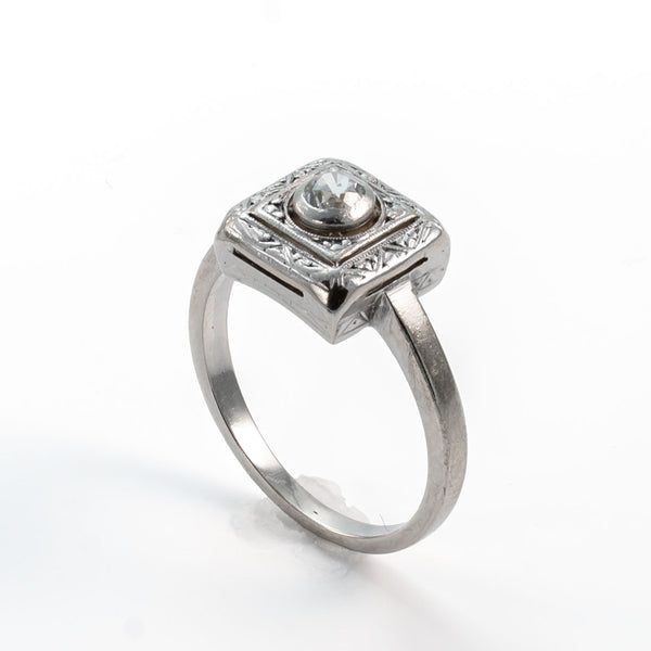 Angled view of a late Art Deco Old European cut diamond ring with recessed bezel setting