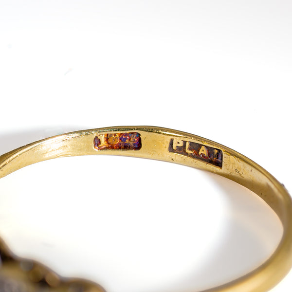 Close-up macro view of authentic British hallmarks stamped 18CT and PLAT inside the 18k yellow gold band shank.