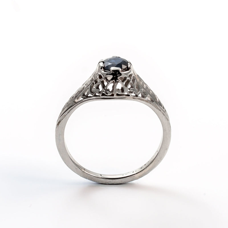 Elevated straight-on view of a vintage sapphire ring in a secure four-prong filigree mounting.