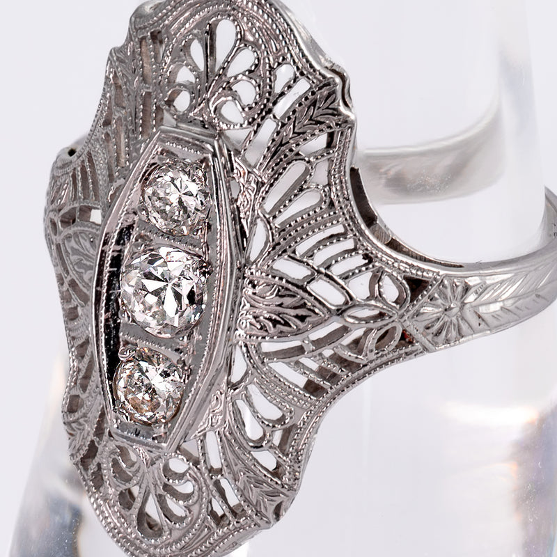 Macro angle of three vertical transitional cut diamonds in milgrain filigree setting.