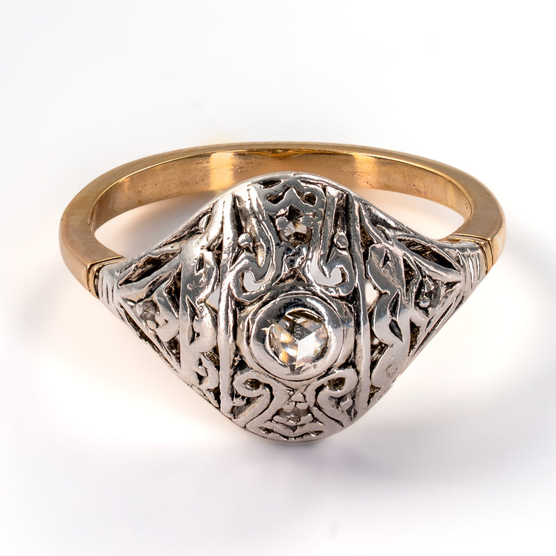 Front elevated perspective of Edwardian two-tone dome ring with pierced scrolling ribbon filigree and rose-cut diamonds