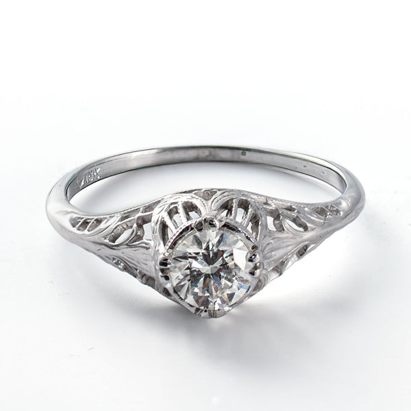Elevated view of a vintage diamond solitaire ring with intricate openwork details
