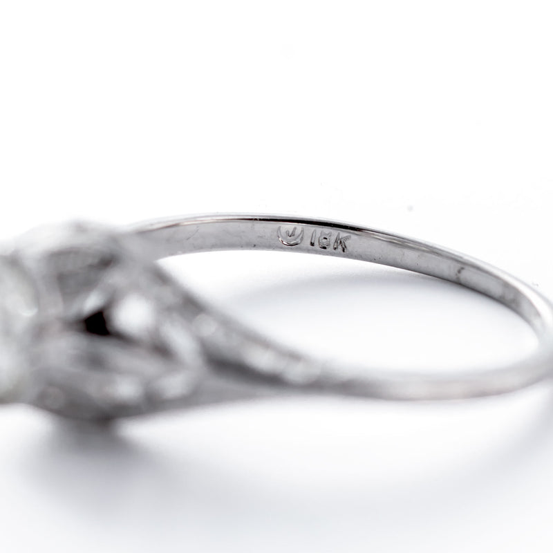 Close-up of a silver ring with '14K' marking on a white background