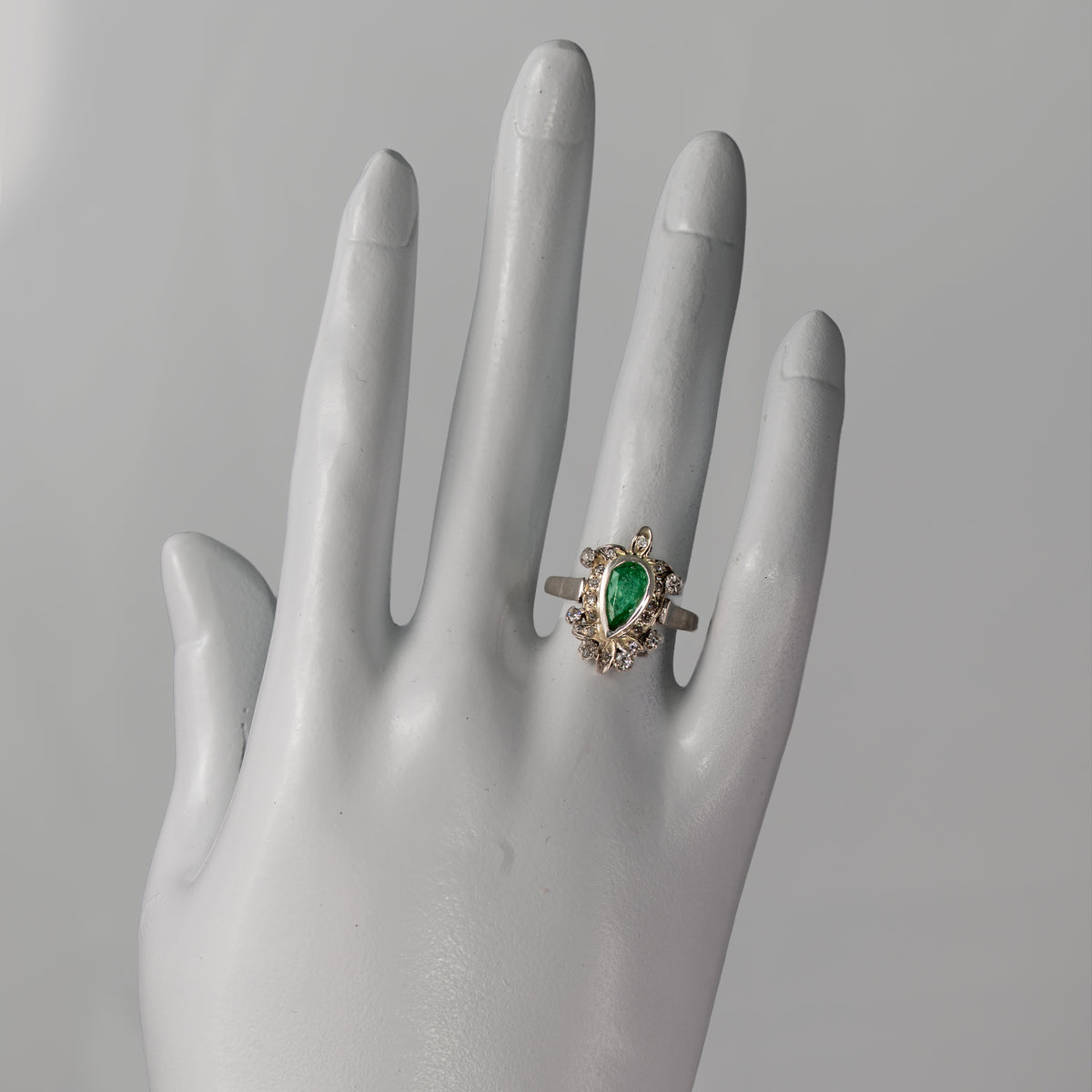 Vintage 1940s palladium pear emerald and diamond foliate ring shown on hand for scale