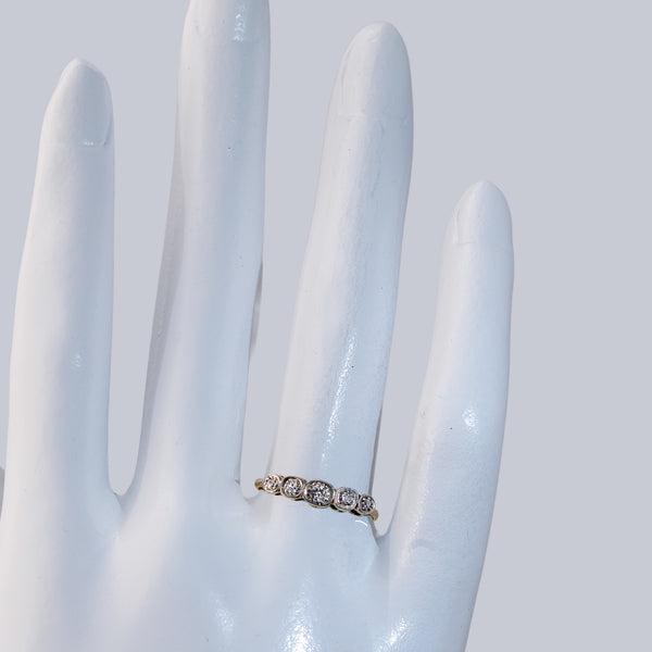 Hand shot of an Edwardian diamond band featuring 5 old European cut diamonds