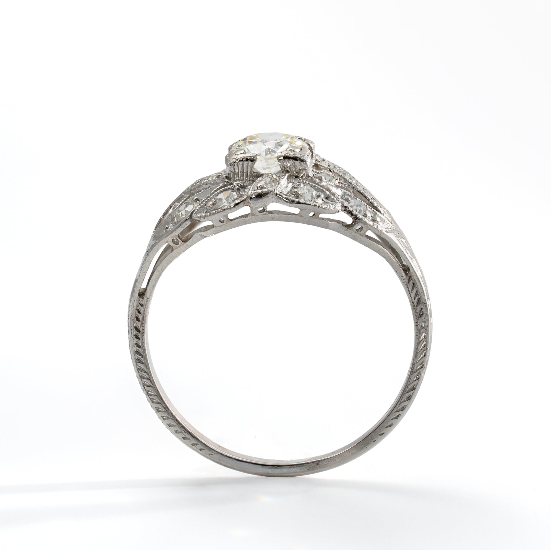 Upright view of antique platinum diamond ring showing Old European Cut center diamond and accent stones