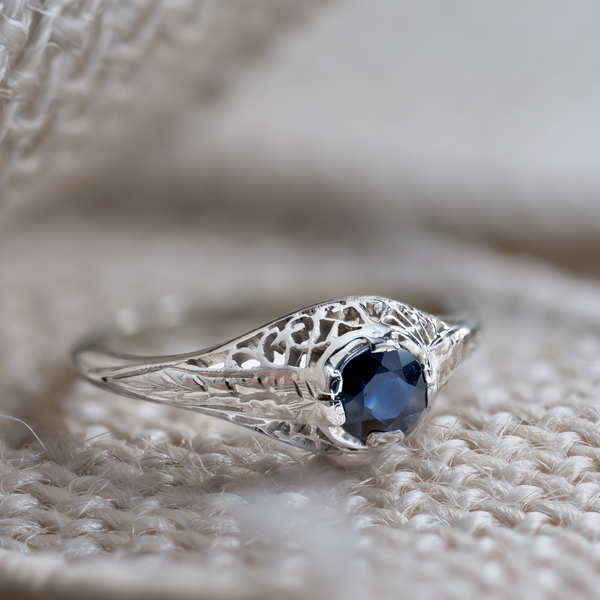 Artistic lifestyle photography of a blue sapphire ring on a textured neutral background for "Soul Value."