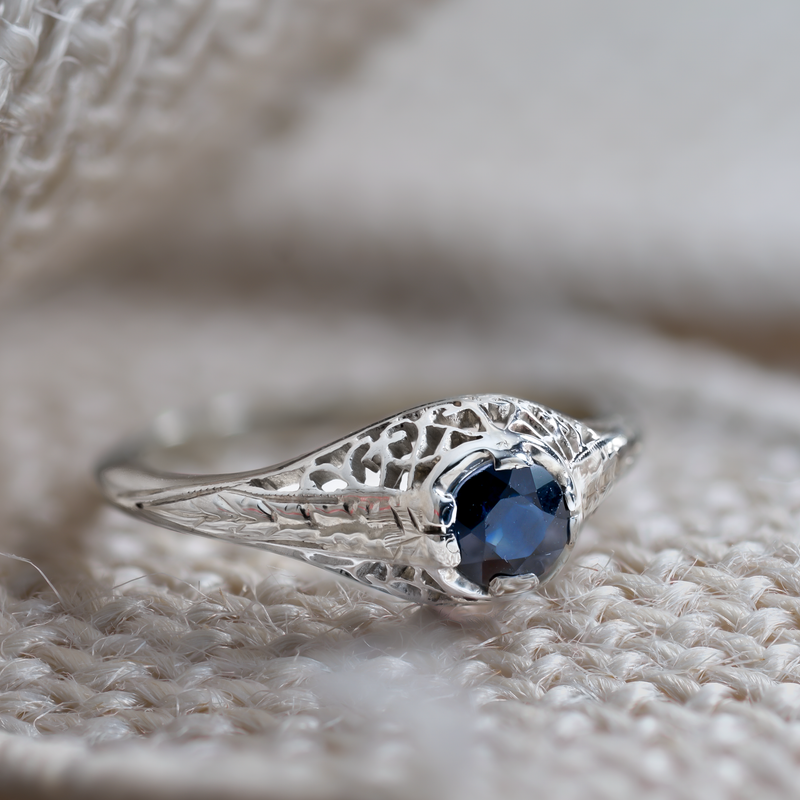 Artistic lifestyle photography of a blue sapphire ring on a textured neutral background for "Soul Value."
