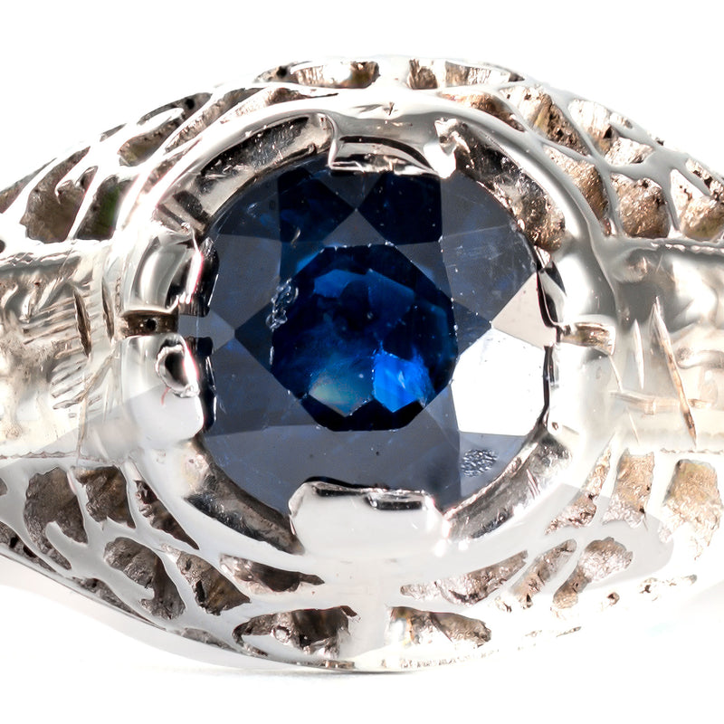 Macro view of a natural blue sapphire showing authentic period facet wear and surface patina.
