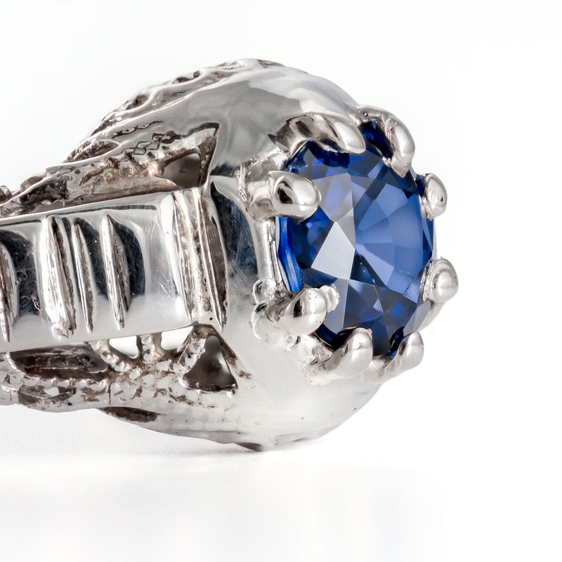 Close detail of natural blue sapphire set in antique white gold mounting