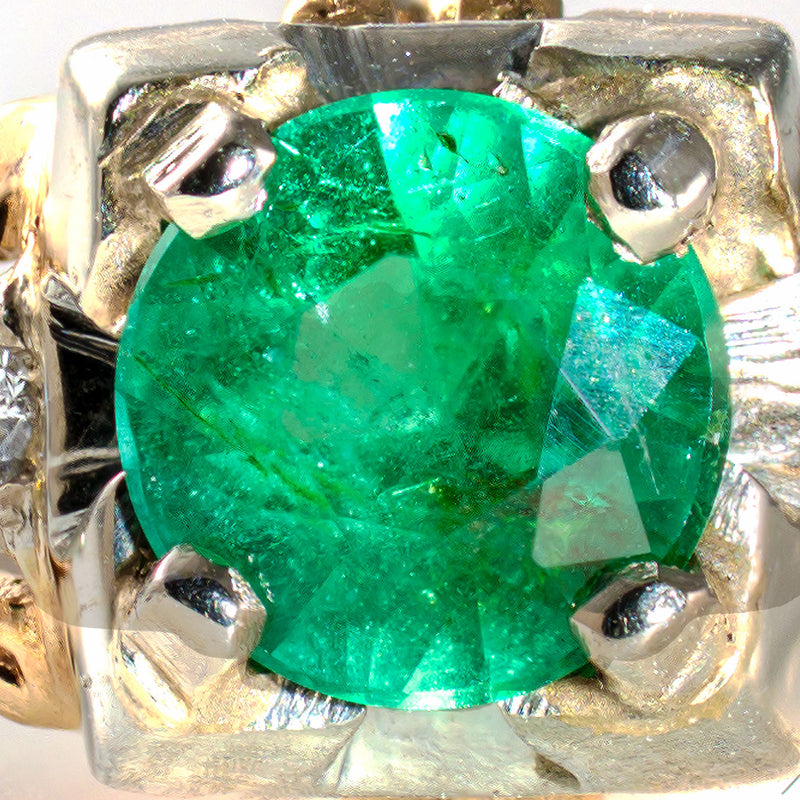 Magnified view of the natural emerald revealing its rich medium-green color and characteristic internal features.