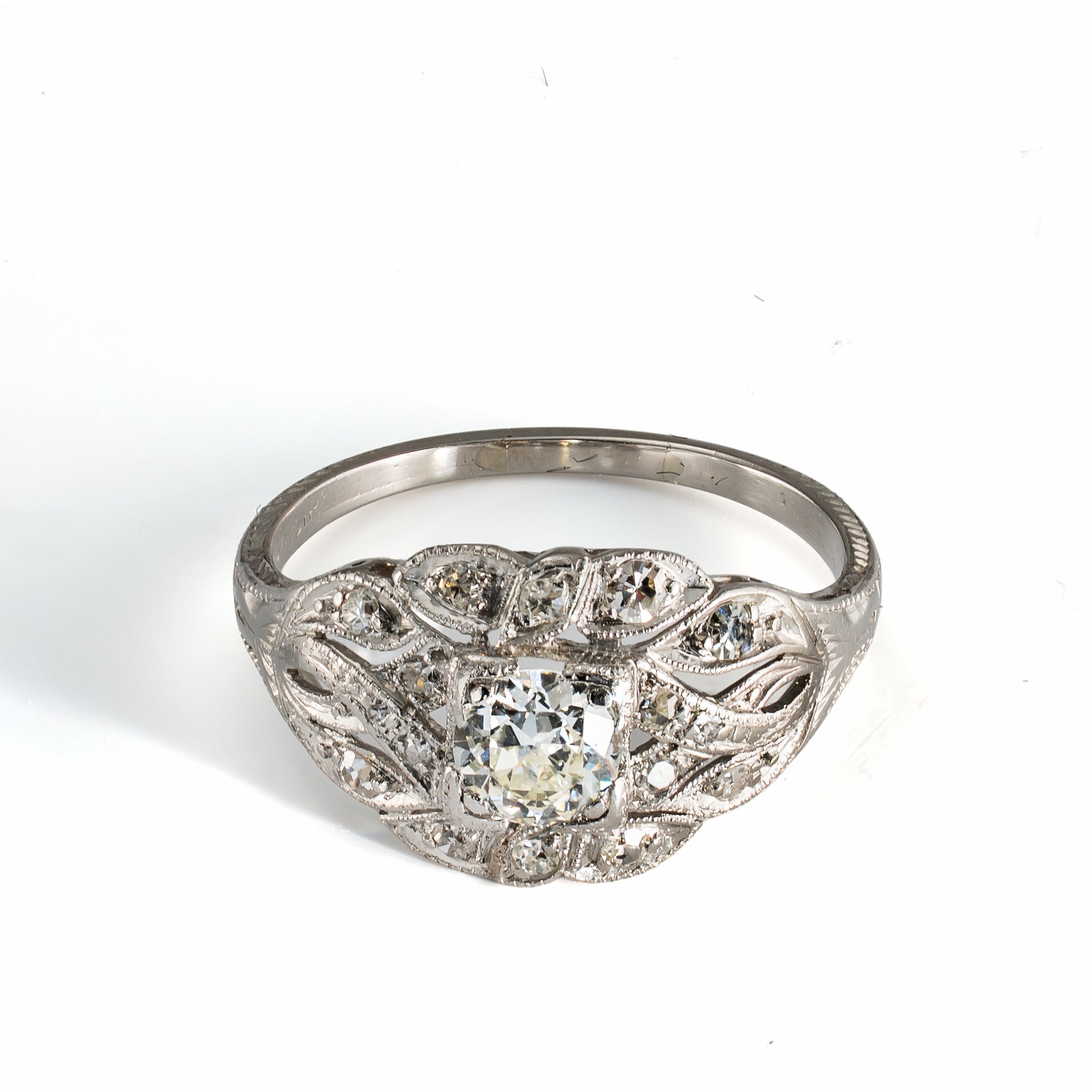 Elevated front view of antique platinum diamond ring with softly raised diamond-set design