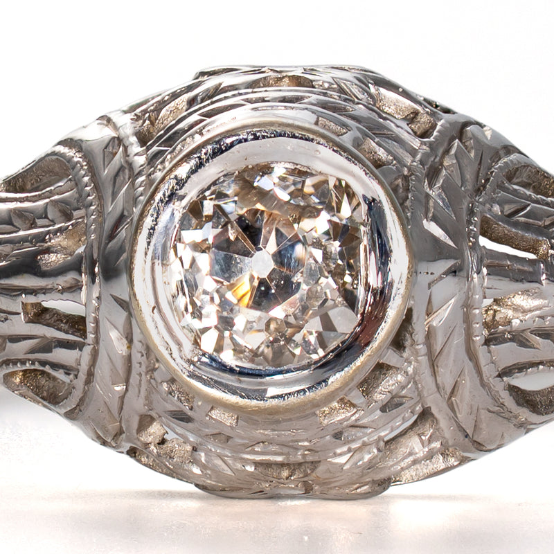 Close-up of the antique hand-cut diamond displaying a high crown, small table, open culet, and subtle warmth within its original bezel setting.
