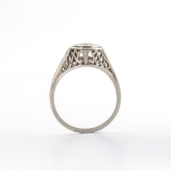 Silver ring with intricate design on a white background