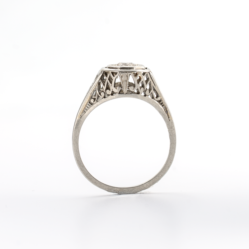 Silver ring with intricate design on a white background