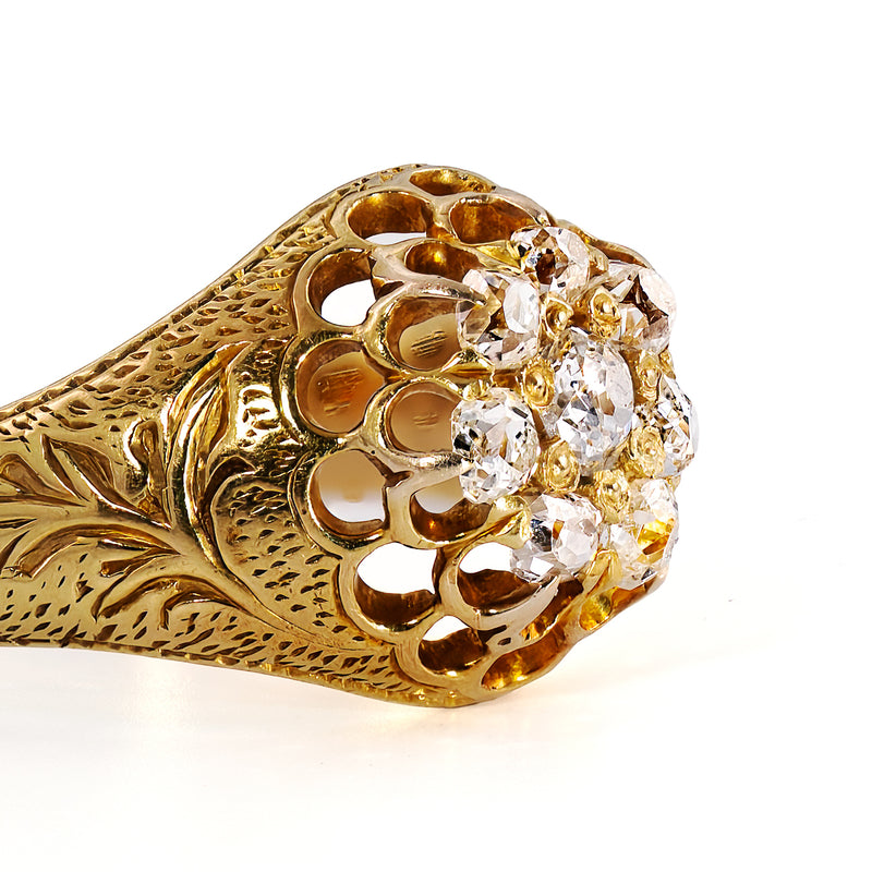 Close-up of the crisp hand engraving decorating the shoulders of an authentic circa 1885 to 1900 gold diamond cluster ring.