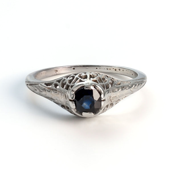 Front view of an architectural white gold filigree ring featuring a natural blue sapphire solitaire.