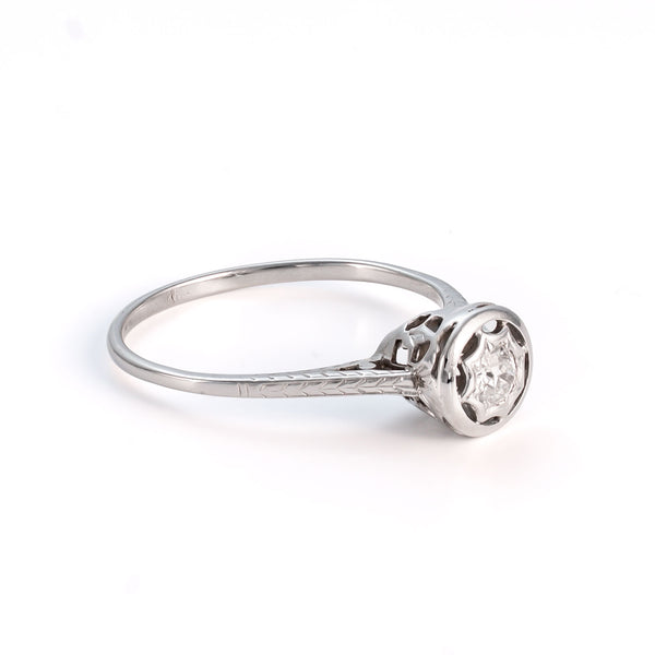Side profile view of a white gold vintage ring showing the crisp chevron-style engraving and geometric openwork basket.