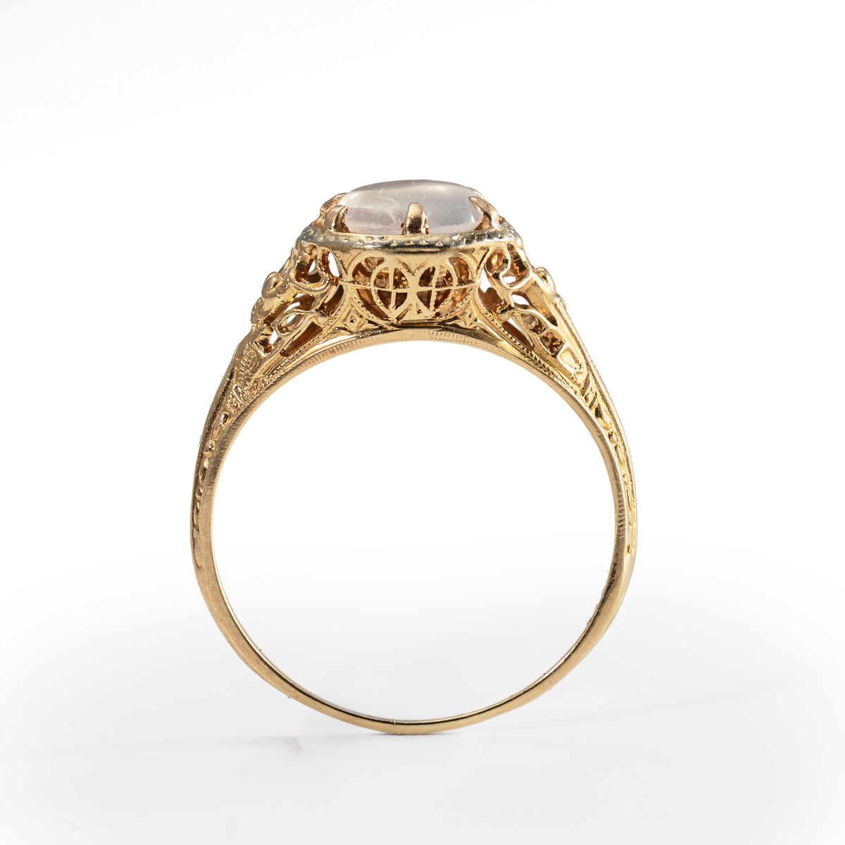 Elevated side profile showing the graceful vintage gold mounting and moonstone