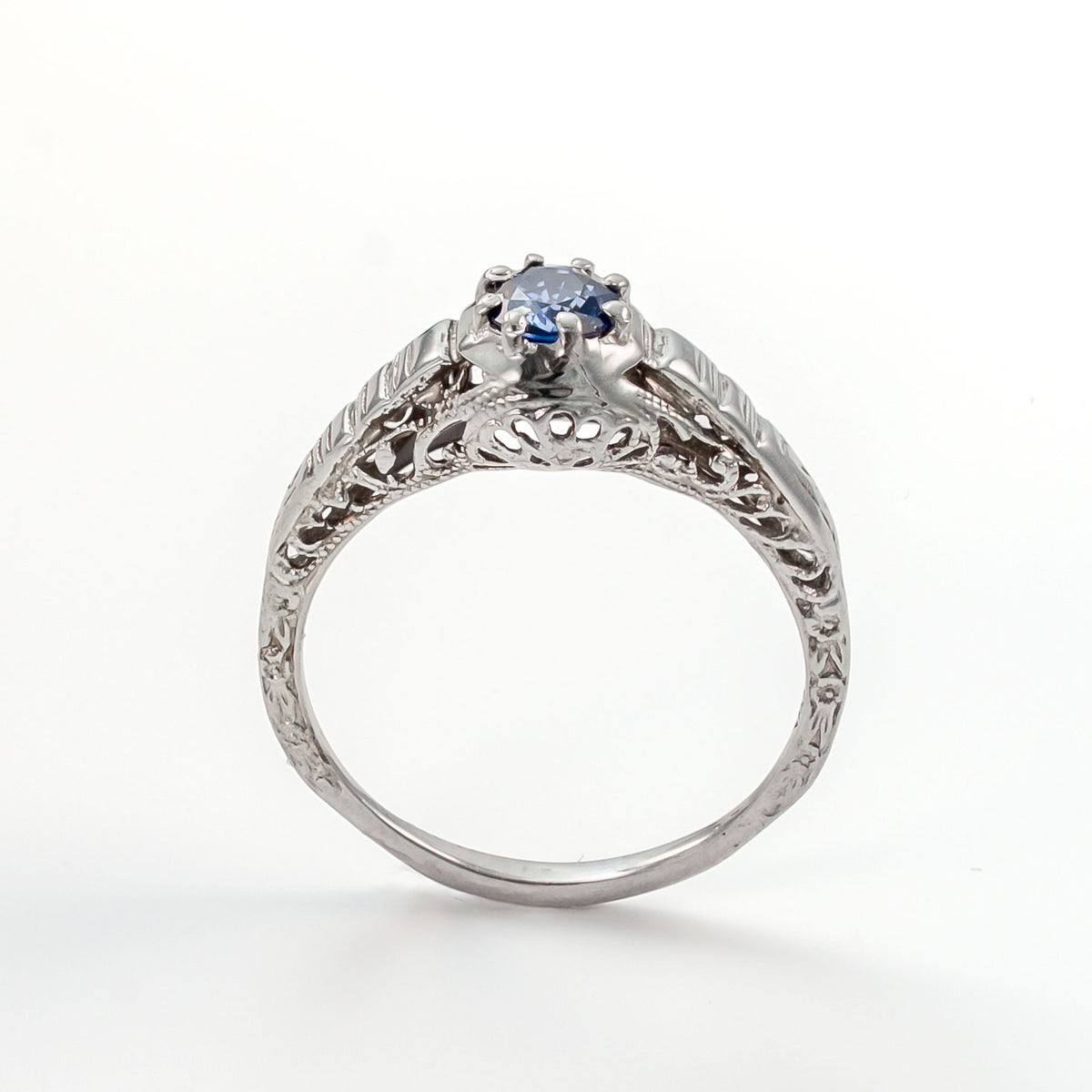 Upright angle of antique sapphire ring highlighting open gallery and handcrafted details