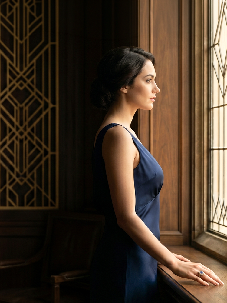 woman wearing an antique ring whole staring out a window