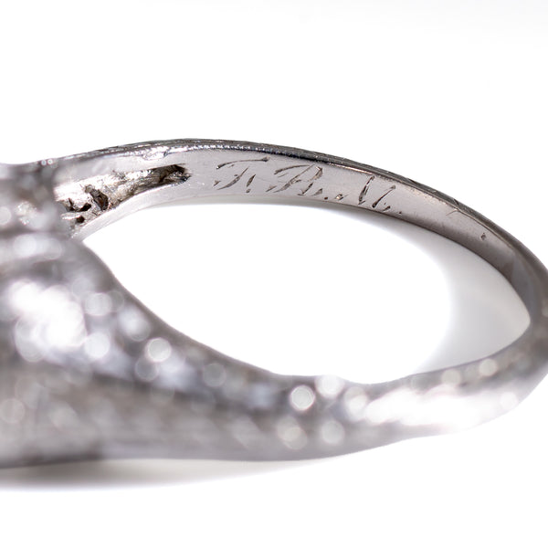 Close-up of the inner band of an authentic 1920s Art Deco platinum Toi et Moi ring, displaying a hand-engraved period monogram and fine hand-tooled metalwork.
