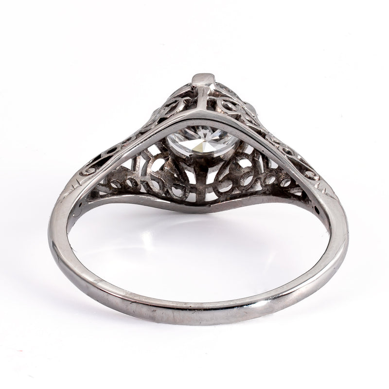 Side view showing engraved wheat-pattern shoulders and four-prong head on an Art Deco filigree ring