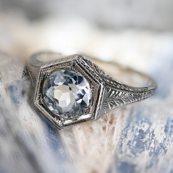 Art Deco Belais ring featuring a 1.30-carat pale icy aquamarine in an 18K white gold hexagonal frame with engraved shoulders.