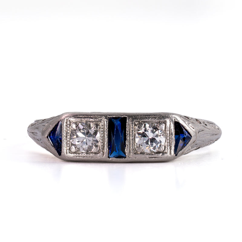 face-up view of a classic Art Deco platinum ring, demonstrating the perfect proportion and architectural rhythm of alternating diamonds and sapphires.