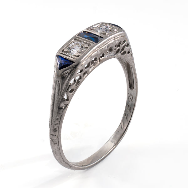 Standing oblique photograph of the vintage platinum band, featuring the intricate pierced openwork gallery and detailed shoulder engraving characteristic of late Art Deco artistry.