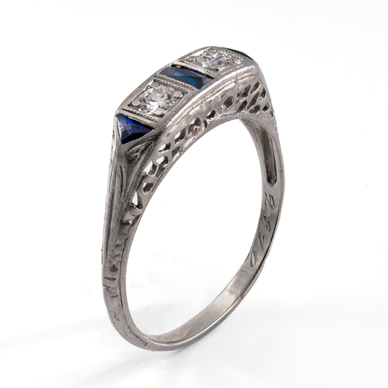 Standing oblique photograph of the vintage platinum band, featuring the intricate pierced openwork gallery and detailed shoulder engraving characteristic of late Art Deco artistry.