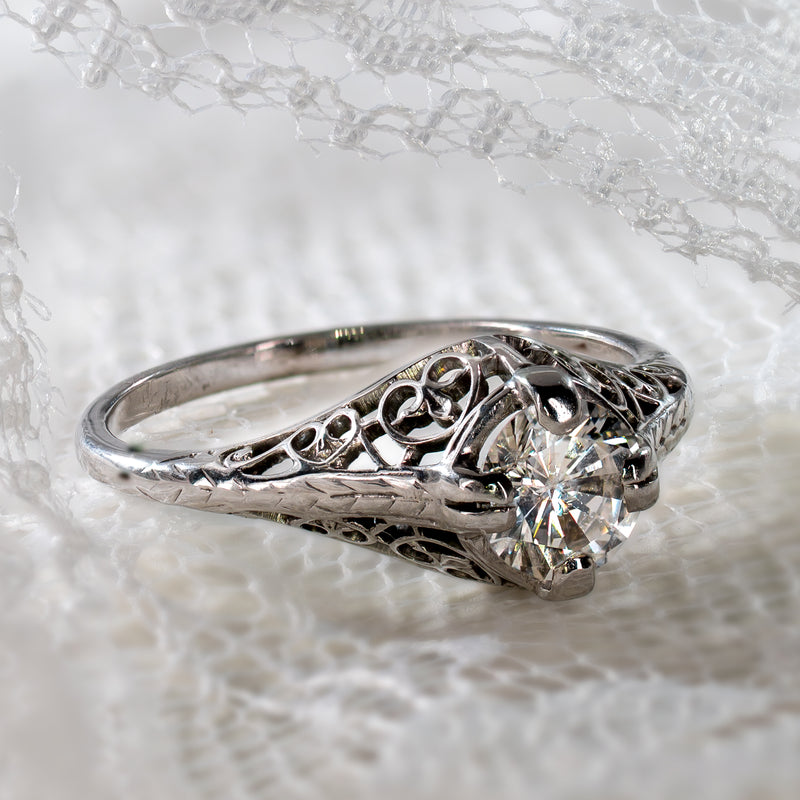 Authentic early Art Deco 18K white gold filigree solitaire ring featuring a transitional cut diamond