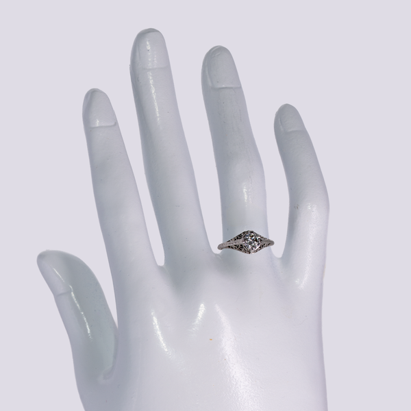 scale shot of art deco diamond solitaire on a display hand
