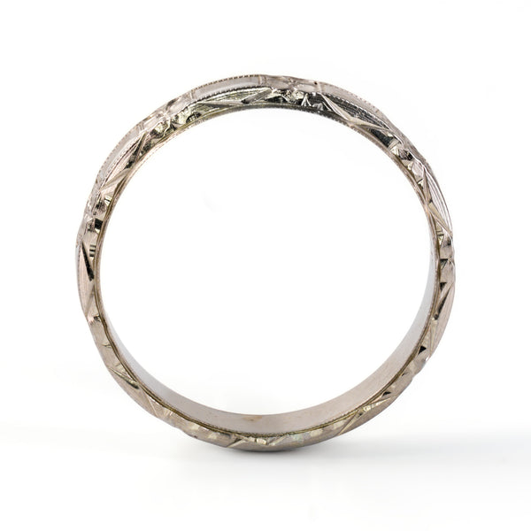 Side profile of antique Belais 18K white gold band showing full circumference chevron engraving along outer rim.
