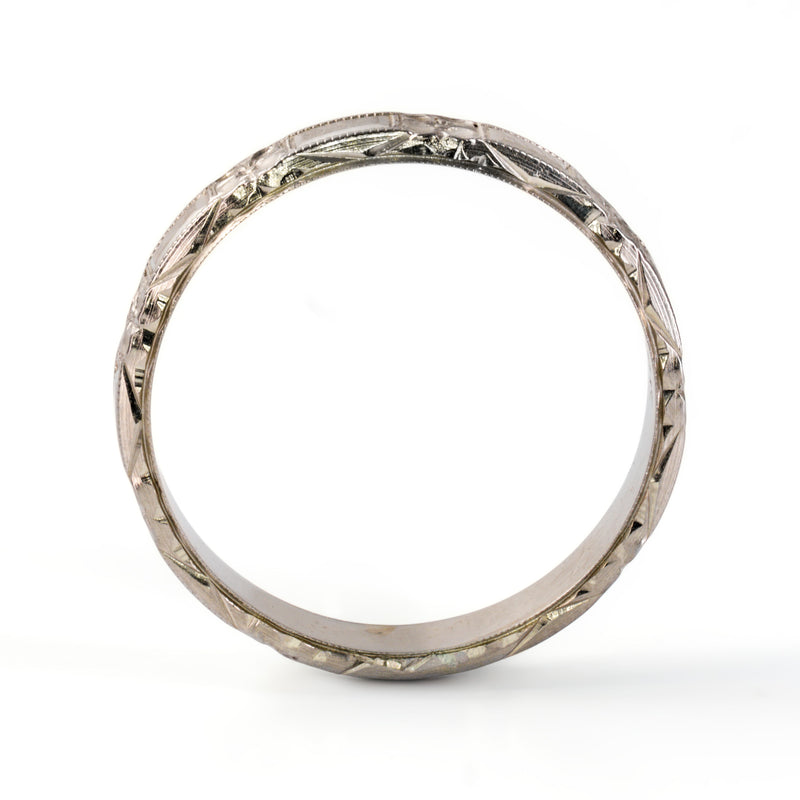 Side profile of antique Belais 18K white gold band showing full circumference chevron engraving along outer rim.