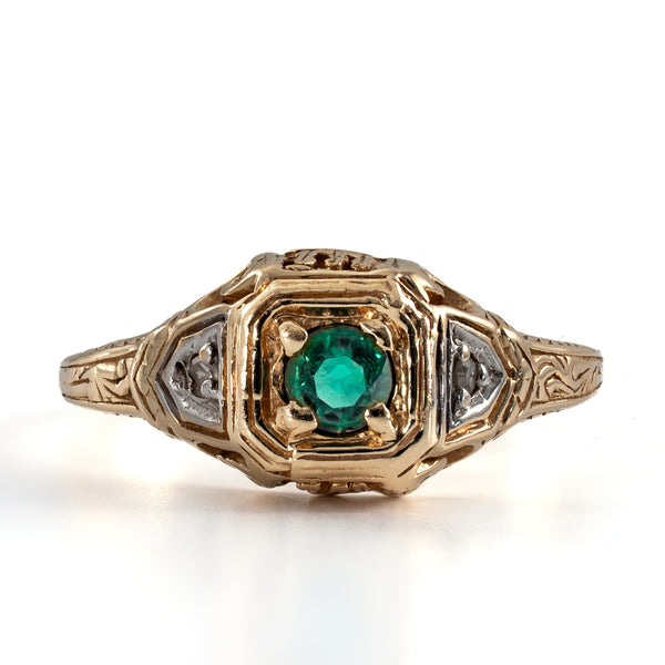 Overhead direct view of the geometric square center head, round green emerald, and symmetrical two-tone accents.